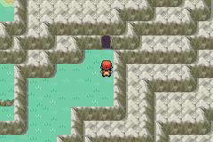 The player on a grassy ledge of Mt. Ember, facing the dark cave mouth of the Ruby Path in the rock face